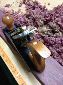 Planing purpleheart parallel bar to attach to a roubo bench leg vise