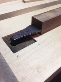 Forged bench hook in action biting into a piece of walnut