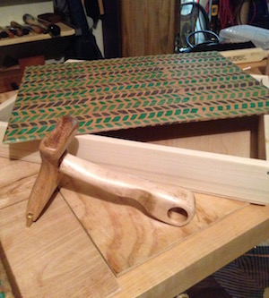 Veneer hammer and a box lid with vellum paper affixed.