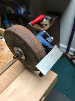 Old bench grinder with old, worn wheel.