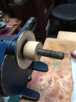 A shop made wood bushing to fit new wheel arbor holes.