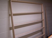 Dry fitted album rack in progress leaning on workspace wall