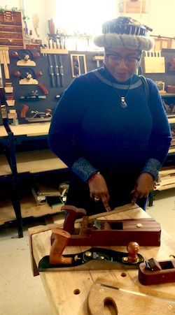 Shirley J in fur rimmed hat during a visit at woodworking school in Toronto