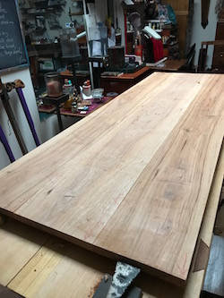 Pecan panels on workbench held steady by bench hook
