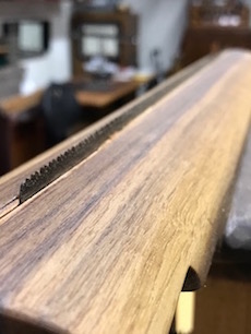 A view down the long saw line of a saw in the saw sharpeing vise.