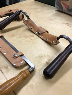 Drawknives in newly made leather sheaths before dye staining.
