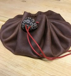 Flexible leather string sack for carrying small tools and accessories on the fly.
