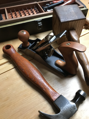 Bench hand plane with hammer and wood mallet on bench.