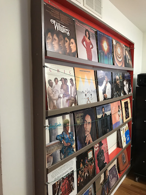 Vinyl album rack anchored to the wall with albums.