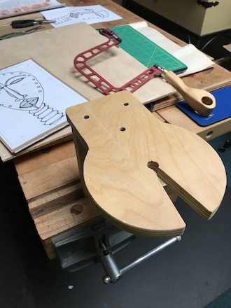 Closeup of the fret saw table with the fret saw and marquetry cartoon in the background.