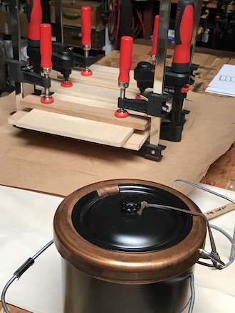 Clamps pressing the marquetry pieces that were reassembled with hide glue; pot in foreground.