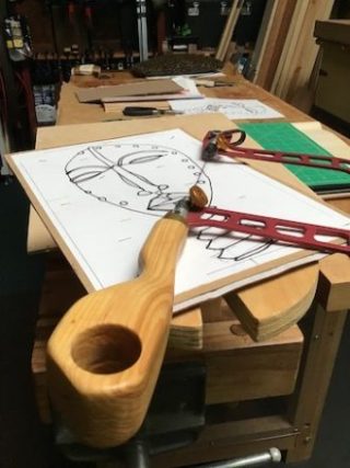 Wooden fret saw in foreground with fret saw and marquetry cartoon.