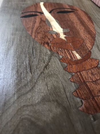 Dan mask marquetry displaying the wood grain after a few coats of shellac.