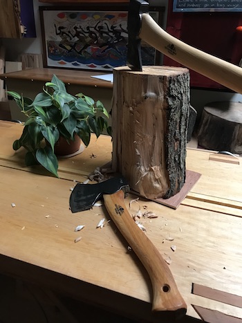 A couple of forest axes on the work bench with a partially riven small elm log.