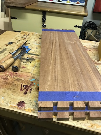 Dovetails cut in the altar cabinet sides shown with bench chisels on wood bench.