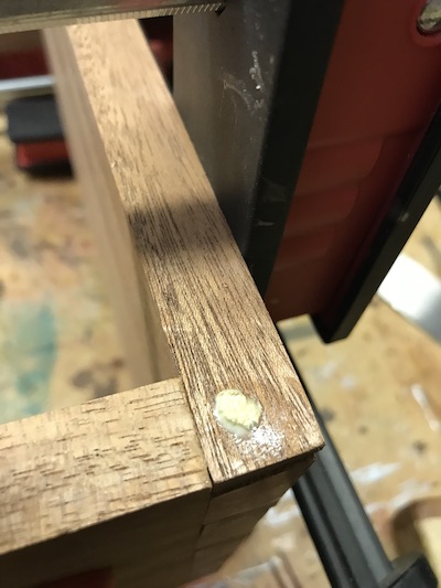 Wood glue squeezed from locked dowel hole through corner dowels.