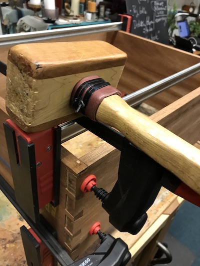 Pinned dovetail showing a wood mallet atop a parallel clamp.