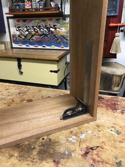 Checking the cabinet carcass for square with an adjustable try square.
