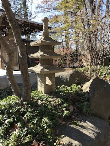 A large Japanese lantern and trees in the garden.