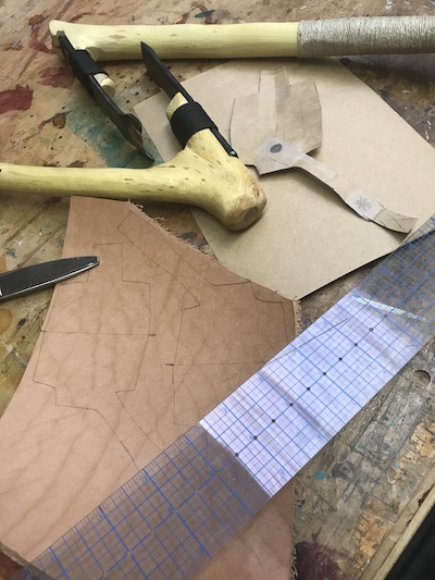 Materials needed to draft an elbow adze pattern: kraft paper, leather, ruler, and scissors.