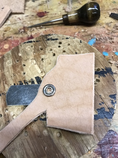 Snap inserted on the top of a leather blank for the elbow adze leather sheath.
