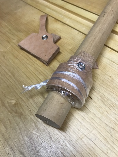 Wet forming the leather on a large dowel to obtain gutter blade curve, covered in plastic. 