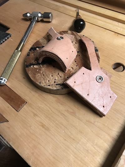 Formed leather sheath with holes punched with an awl to prepare for the rivets.