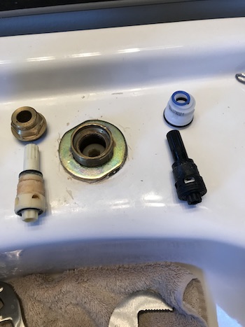 Old and new faucet cartridges shown with adjusting nut before assembling.