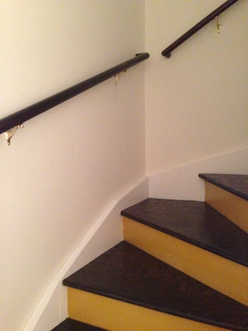 Newly installed salvaged handrails in the renovated stairway.