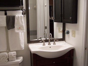 Spa-like guest bathroom with vanity, new faucets, sink and towels.