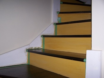 Another view of stairs with painters tape before painting the stringers.