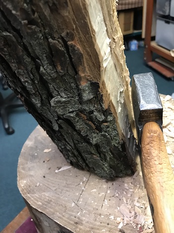 Axe removing bark from a log for bowl carving.