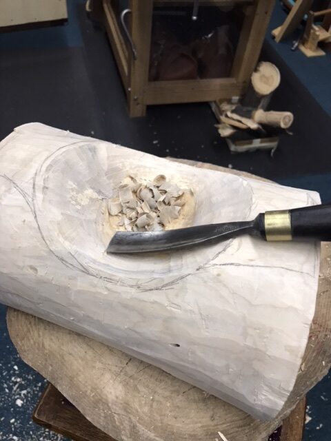 Assisting carving the bowl with a gouge.