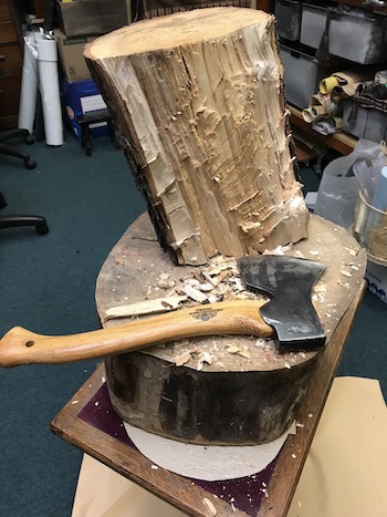 Axe with flattened side of wood log.