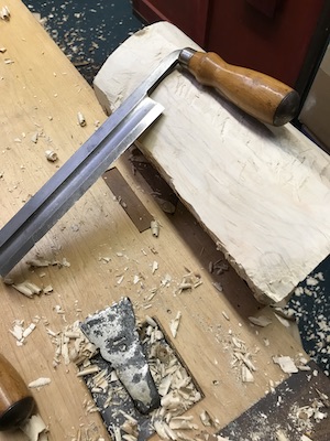 Cleaning the log with a drawknife.