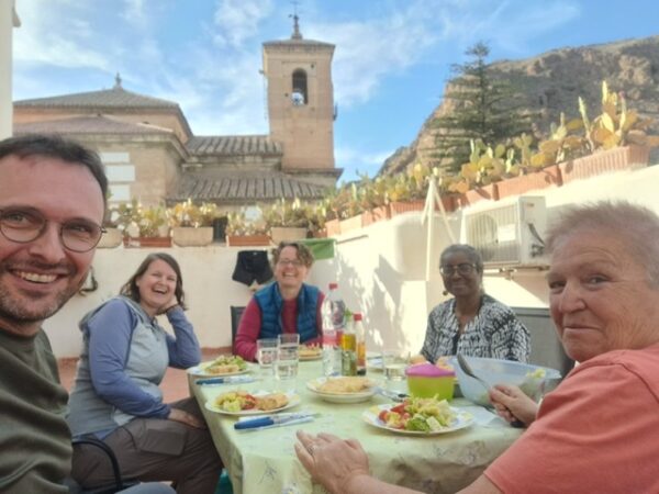 Pilgrims eating a communal meal on the terrace of the albergue on the camino Mozarabe.