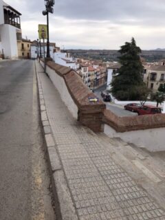 A yellow arrow on a short wall points to stone steps.