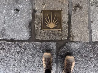 Bronze marker or sign embedded in a sidewalk.