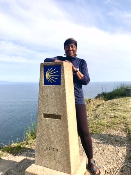 A peregrina at the zero marker at Fisterra, Spain.