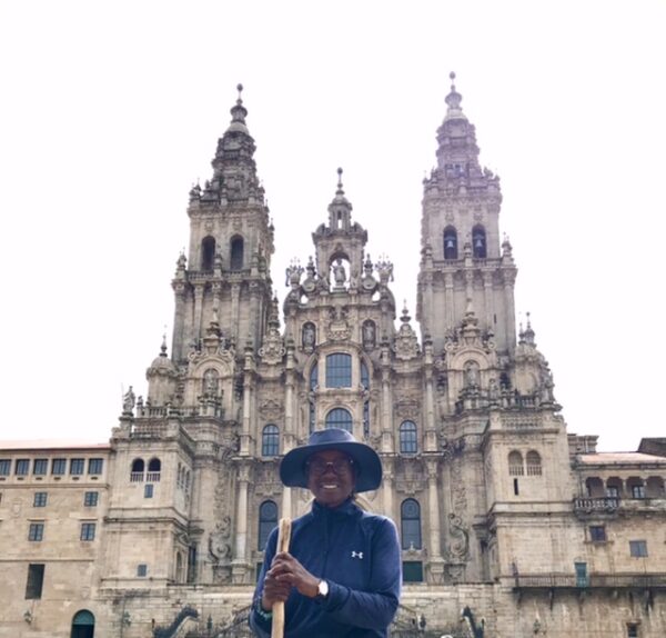 A black woman pilgrim in front of the cathedral in Santiago de Compostela.