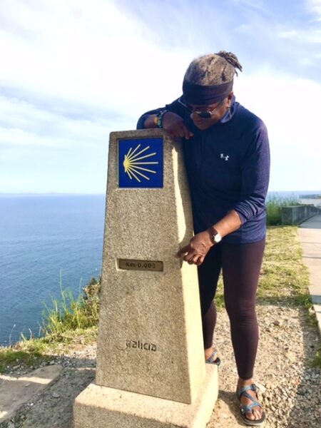 A peregrina looking over the zero marker in Fisterra, Spain.
