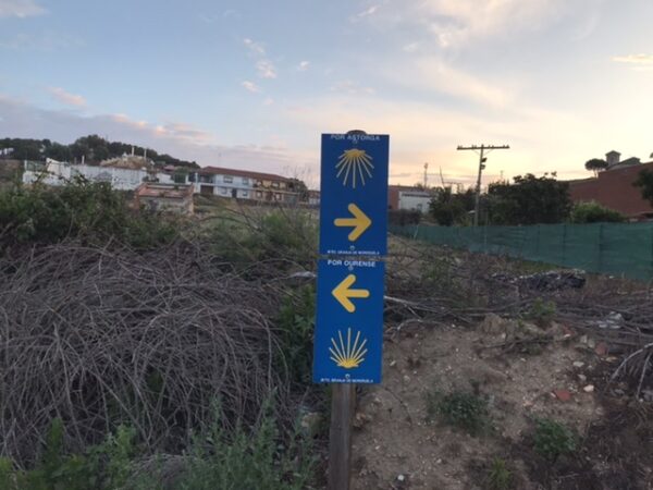 A sign pointing left to Ourense or right to Astorga.