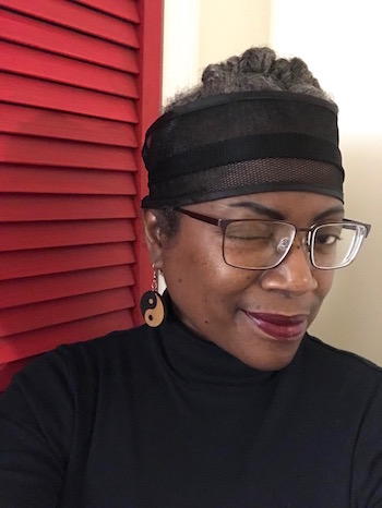 Author winking and wearing  black headband.