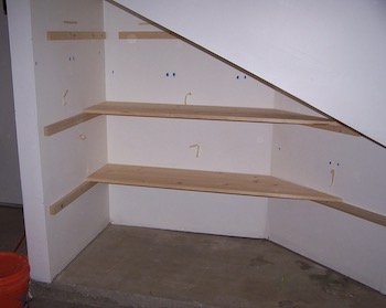 Fitting wood boards on battens in the garage storage space.