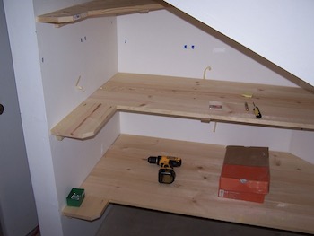 Shelves in garage space under the stairs.