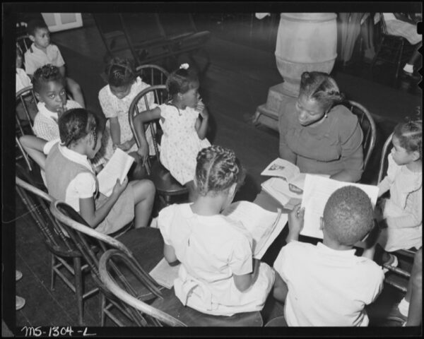 Young black children learn from their Sunday school teacher.