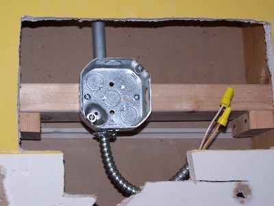 Electrical box installed in the drywall patch.
