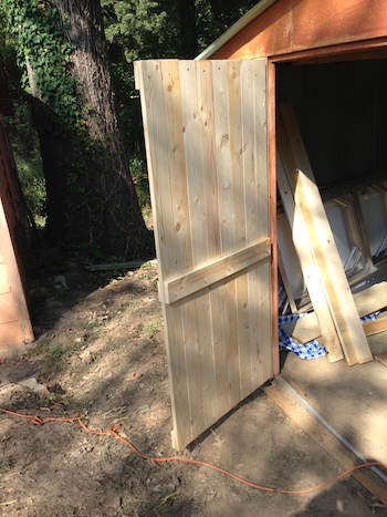 A new shed door on the hinges.
