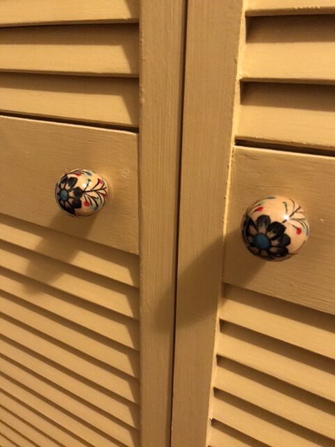 Detail of decorative door pulls on the louvered door.